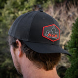 A black NCB snapback hat worn backwards on a model's head